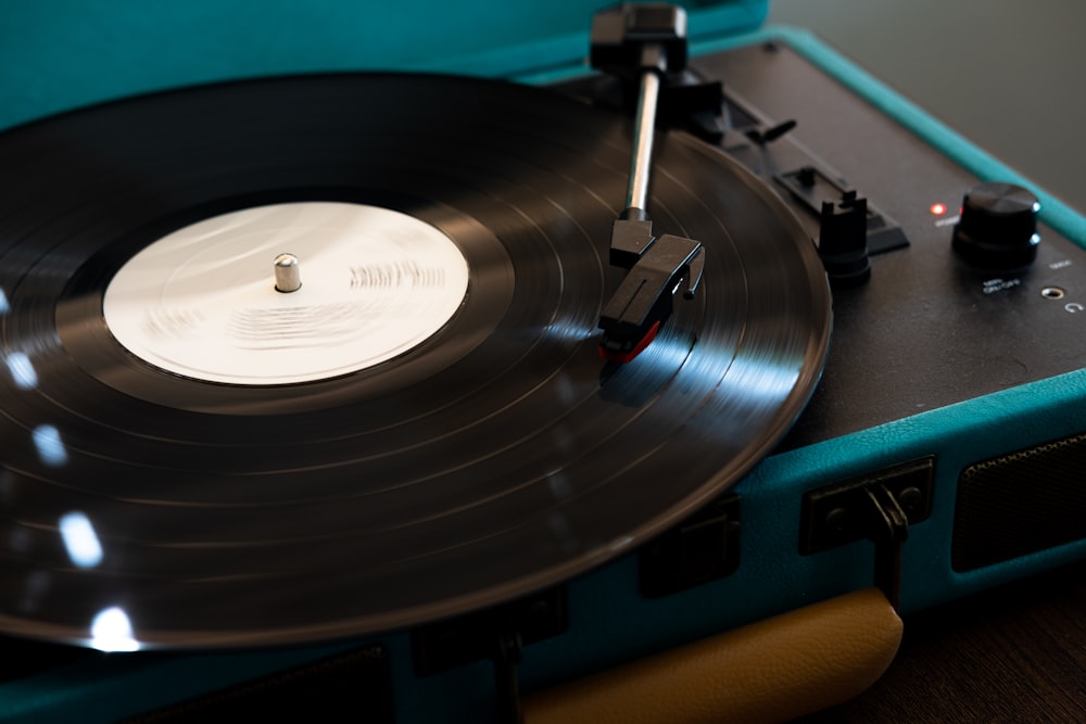 black vinyl record player on brown wooden table