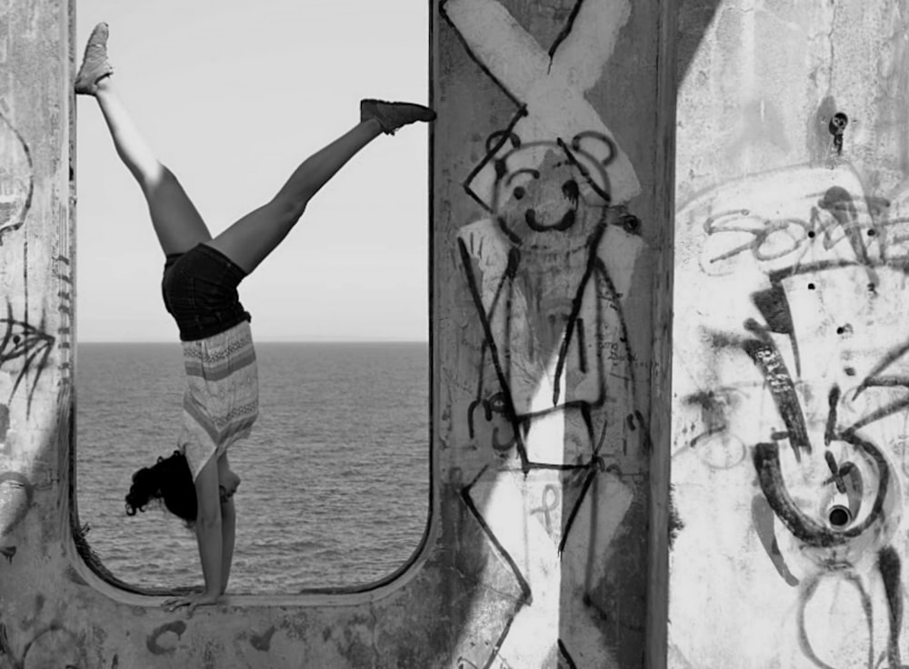 woman in black shorts and white shirt standing on concrete wall