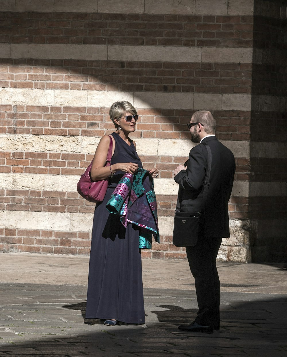 uomo in abito nero in piedi accanto alla donna in vestito nero