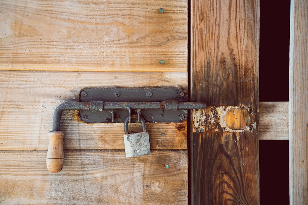 Cadenas noir et argent sur porte en bois marron