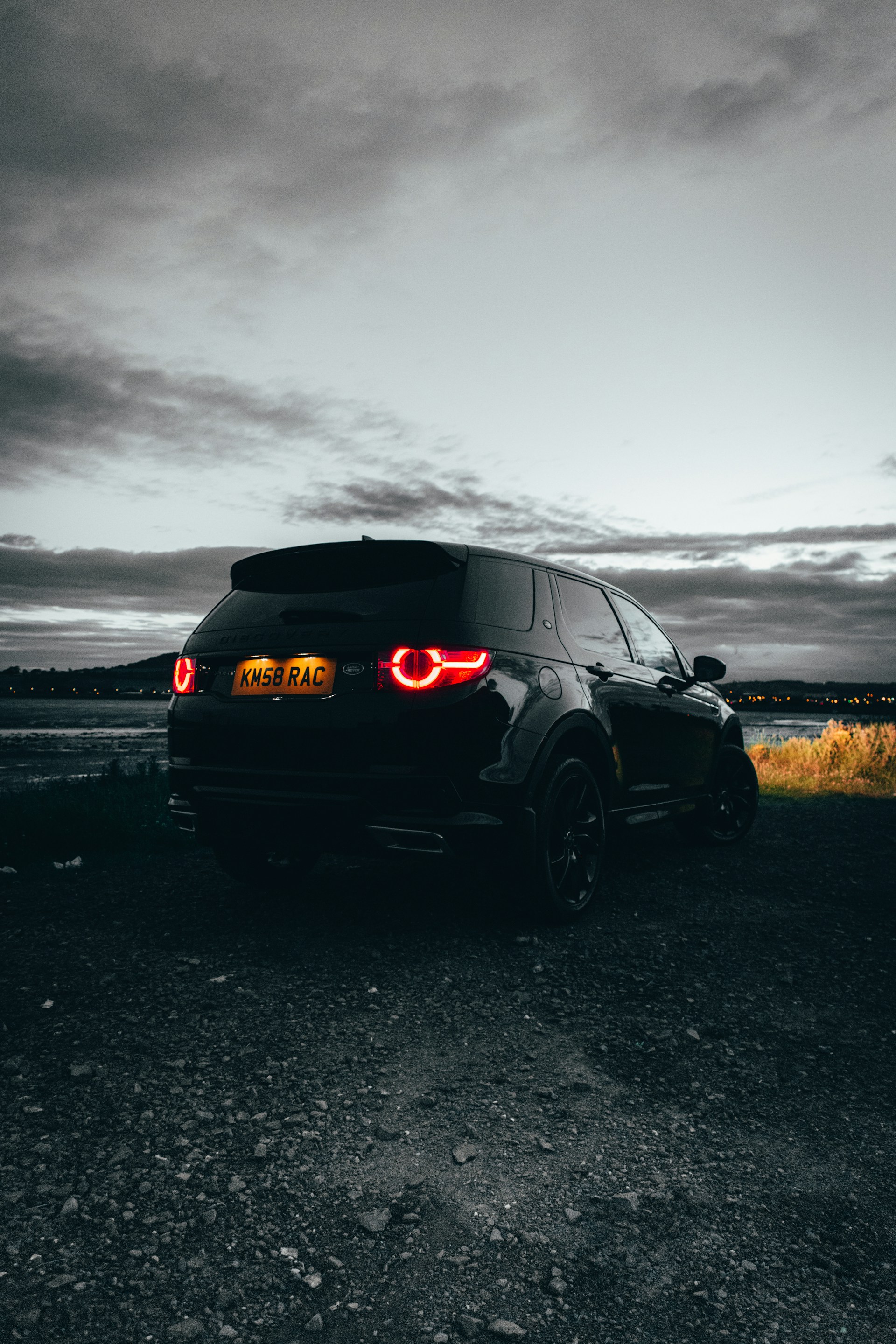 black suv on gray sand under gray sky