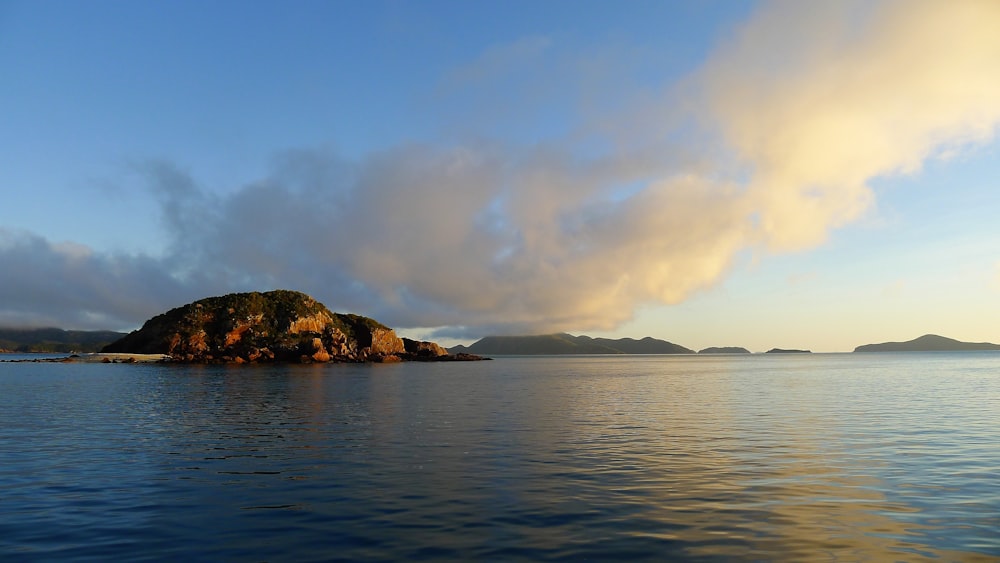 Formation rocheuse brune sur la mer sous les nuages blancs pendant la journée