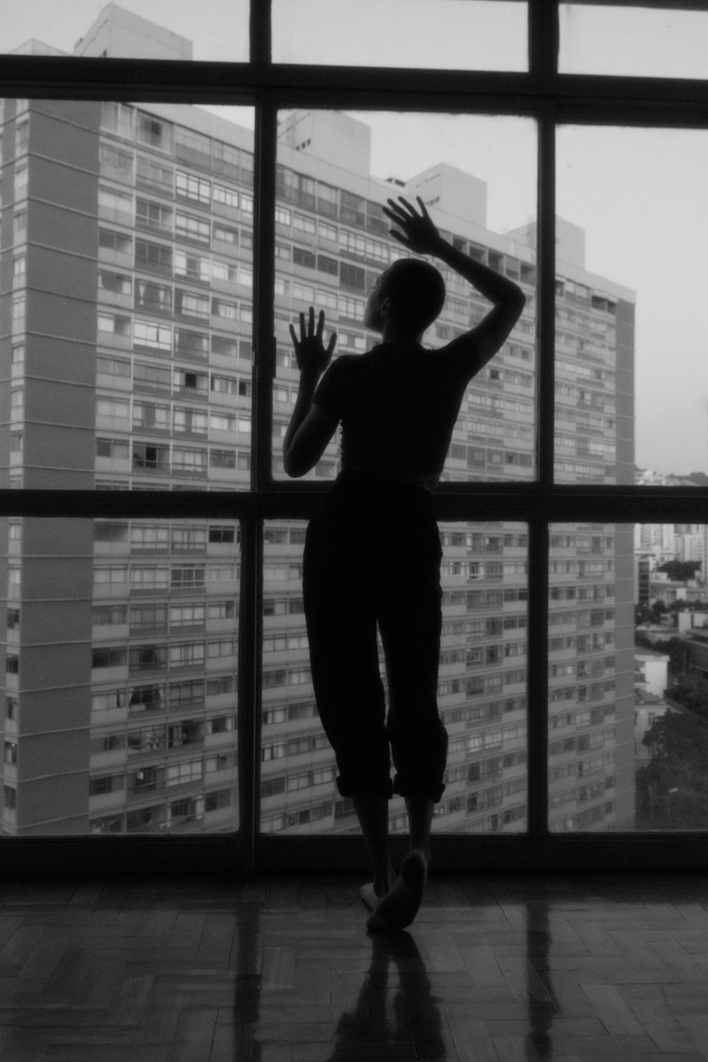 woman in black tank top and pants standing on window