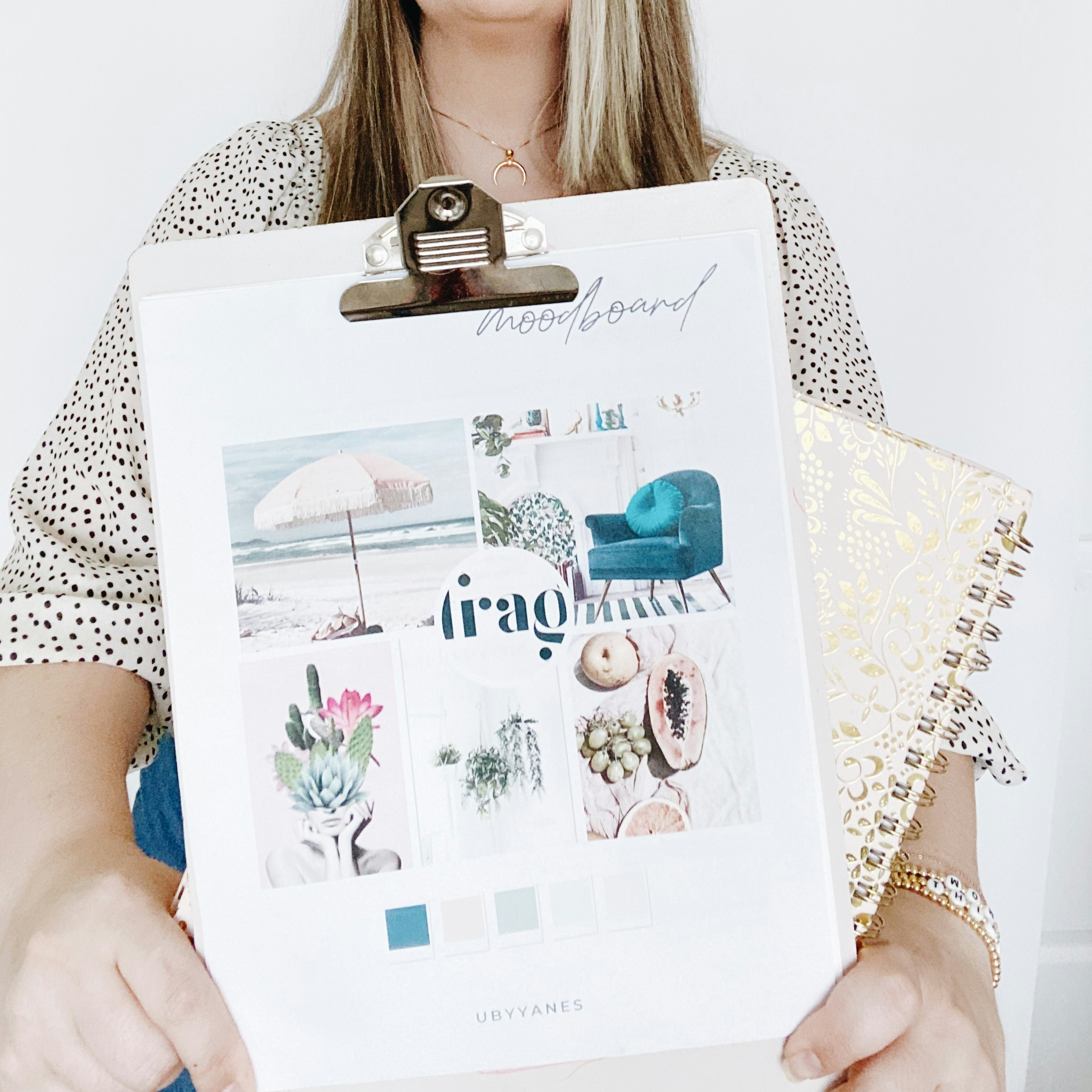 woman in white and black polka dot shirt holding white and pink floral greeting card