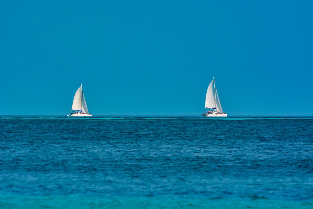 weißes Segelboot auf See unter blauem Himmel tagsüber