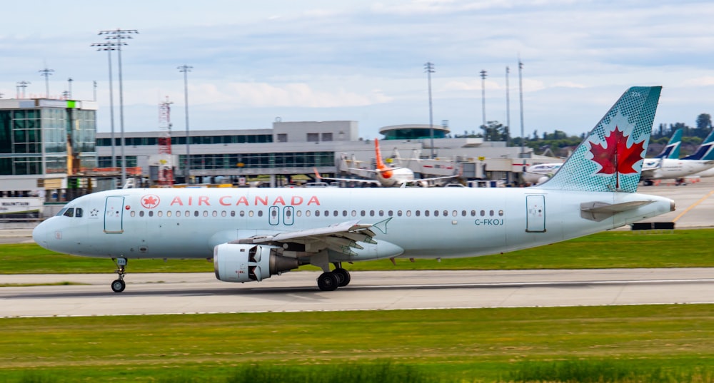 avião de passageiros branco e vermelho no aeroporto durante o dia