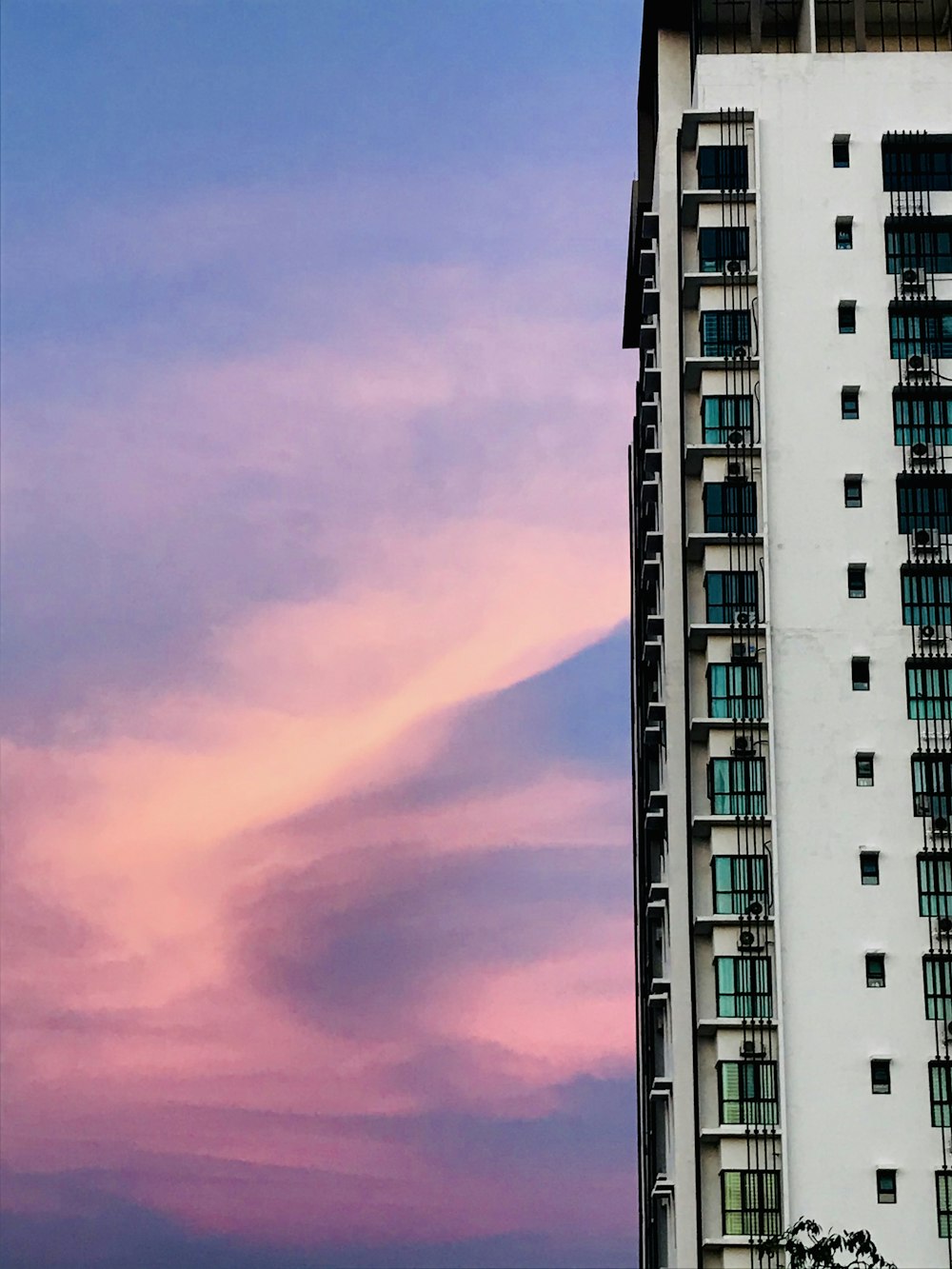 Bâtiment en béton blanc et noir sous un ciel nuageux