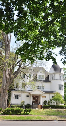 white and brown house near green tree during daytime