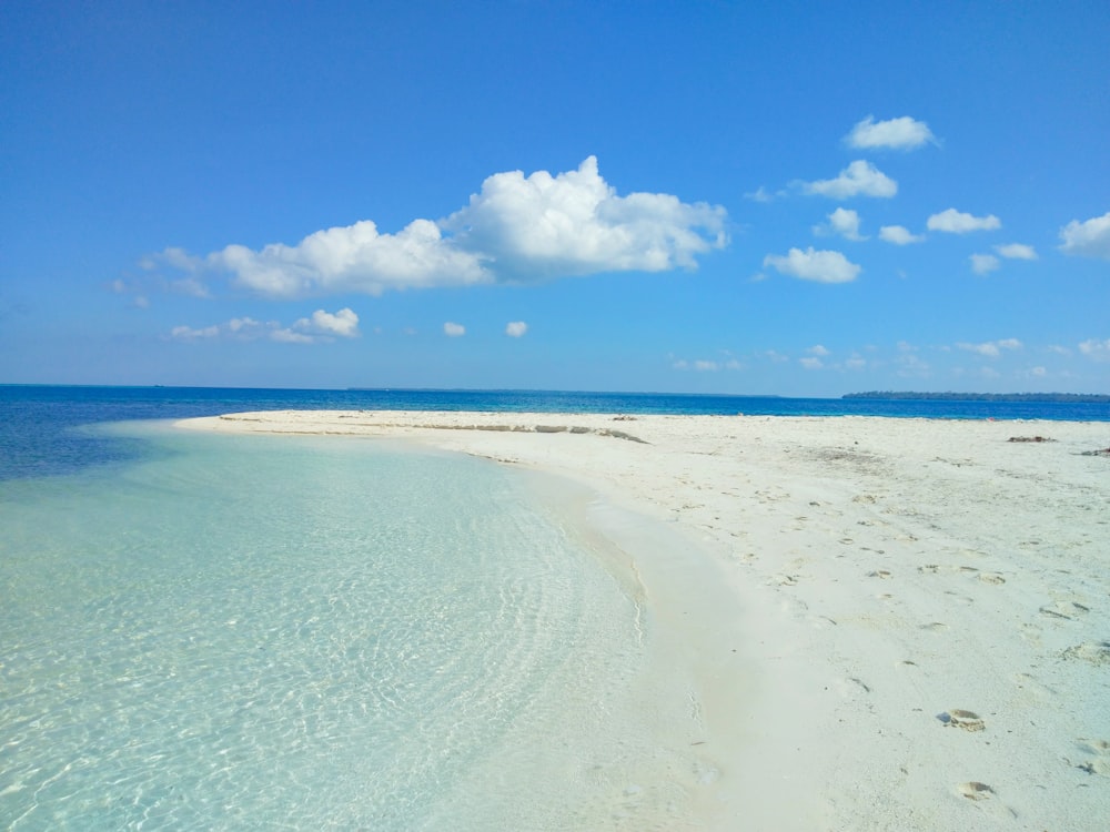 Weißer Sandstrand unter blauem Himmel tagsüber