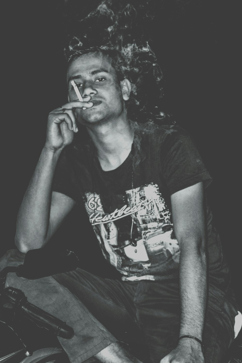man in black crew neck t-shirt smoking cigarette