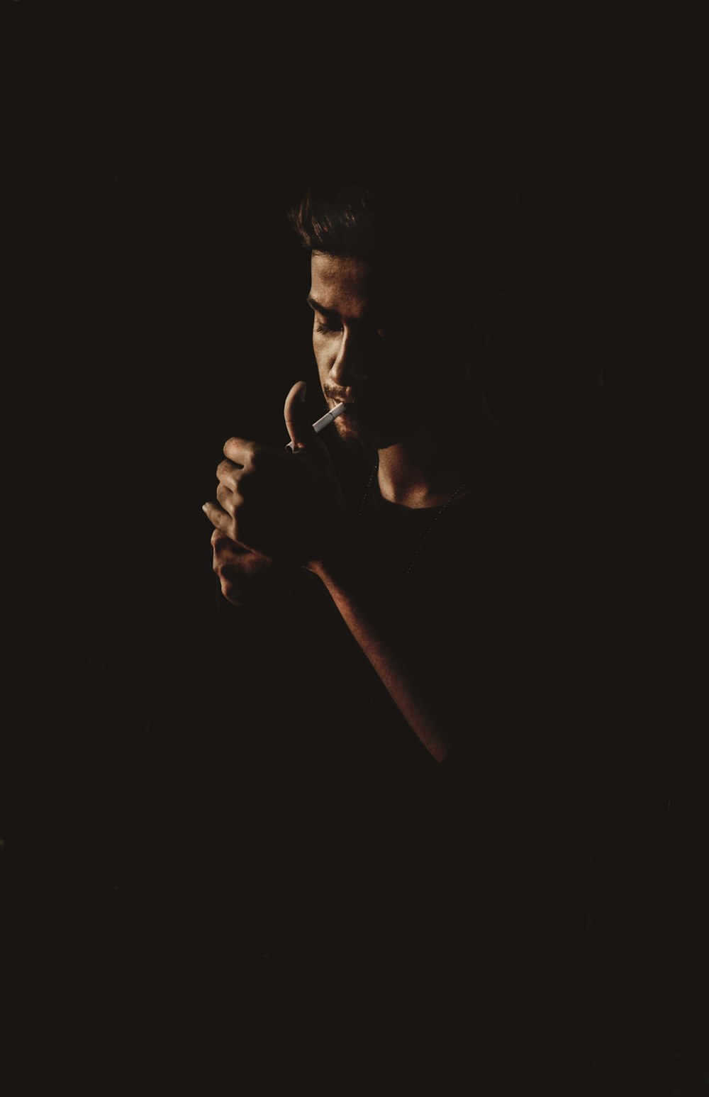 man smoking cigarette in dark room