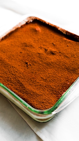 Close-up of creamy tiramisu layers in delicate coupe glasses with cocoa dusting