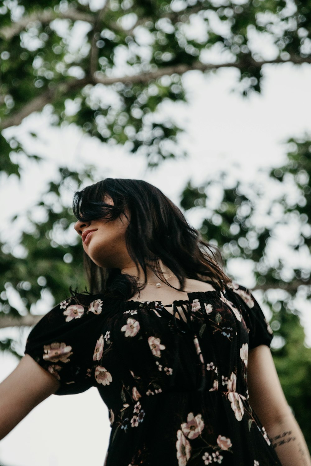 Mujer con camisa floral blanca y negra con gafas de sol negras