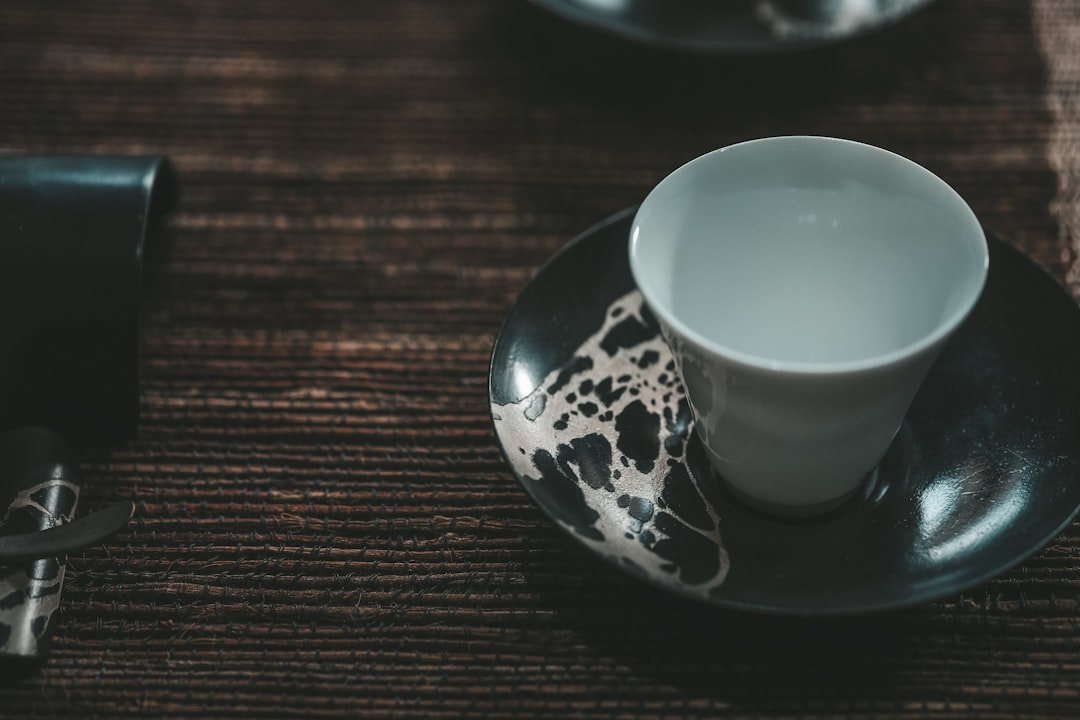 white and blue floral ceramic teacup on saucer