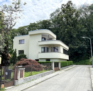 white concrete building near green trees during daytime