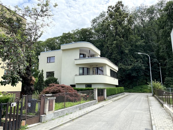 white concrete building near green trees during daytime