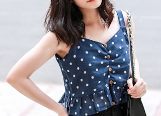 woman in blue and white polka dot tank top and black skirt