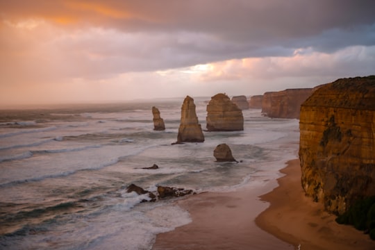 brown rock formation on sea shore during daytime in Twelve Apostles Australia