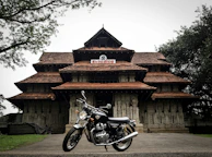 A panoramic view of the Konark Sun Temple with a parked bike in the foreground, inviting exploration.