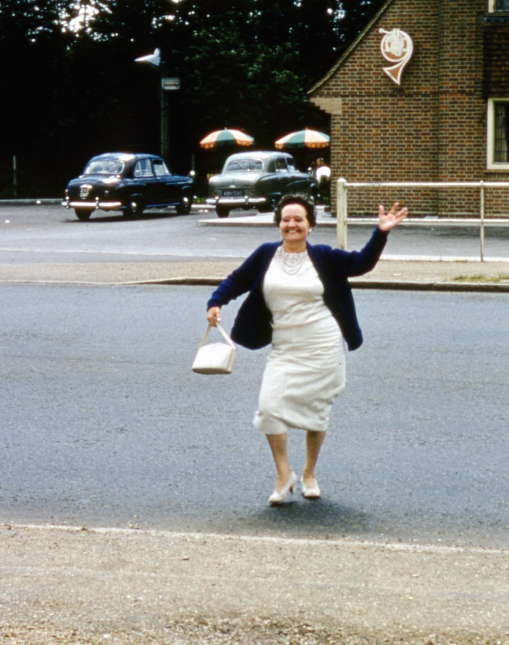 man in black jacket and white shorts standing on gray asphalt road during daytime