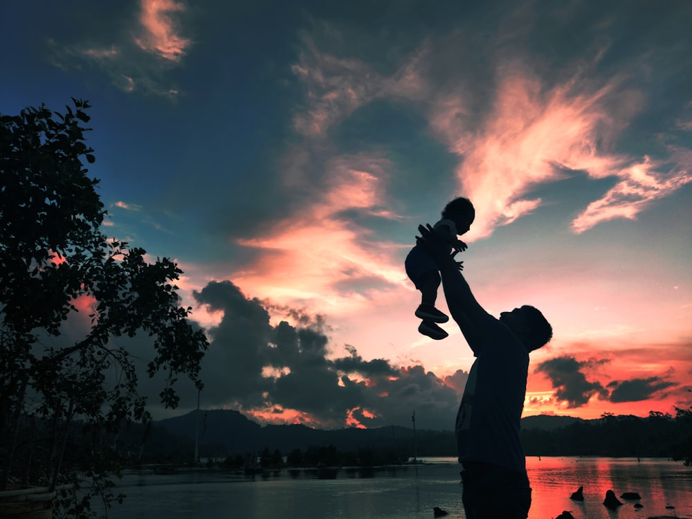 silhouette of man and woman kissing during sunset