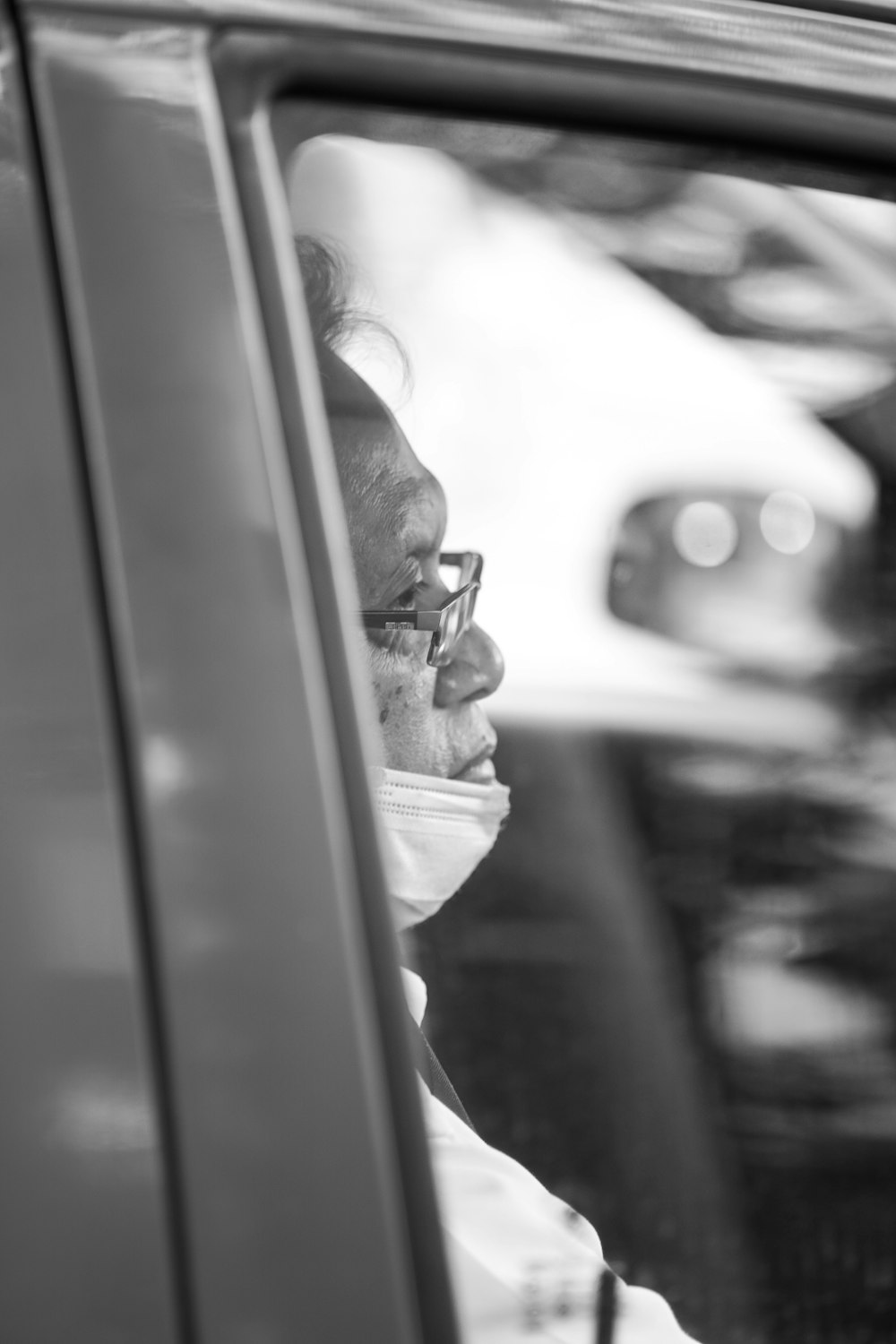 a man sitting in a car looking out the window