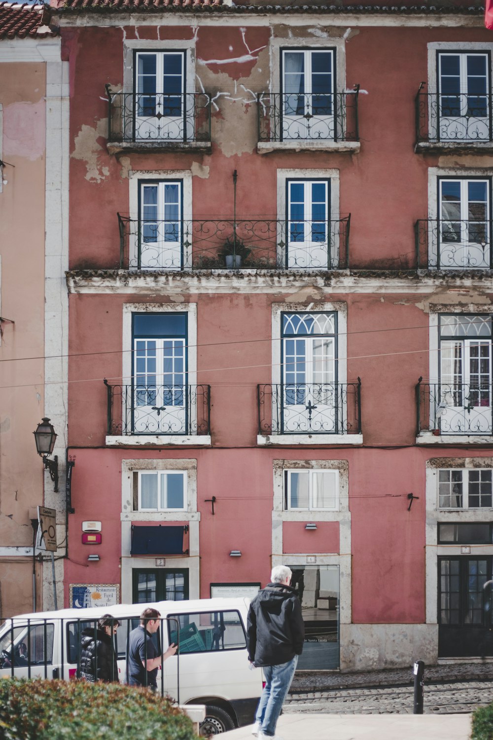 a man standing on a sidewalk in front of a building