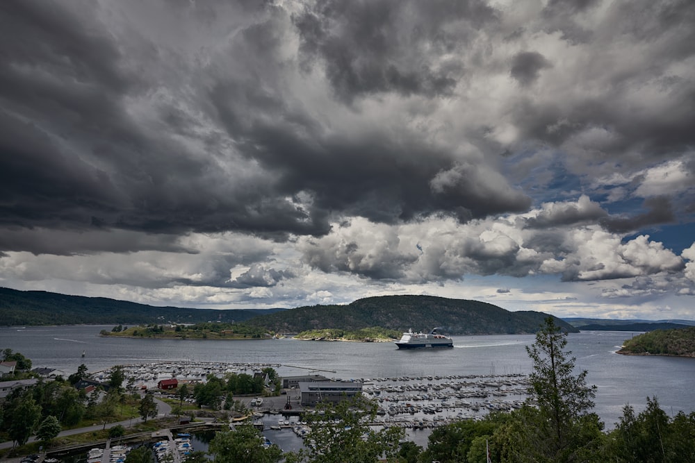 white boat on body of water under cloudy sky during daytime