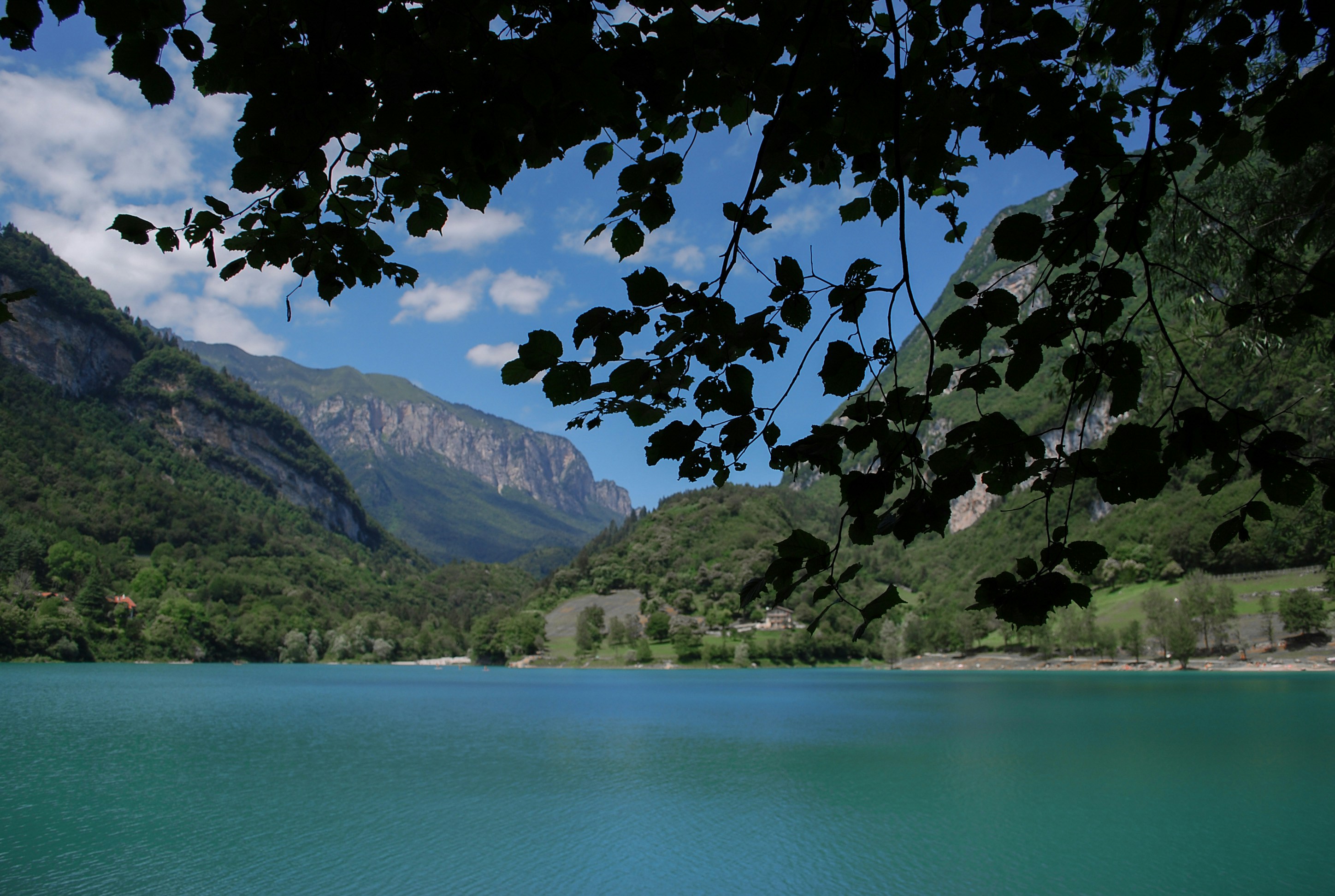 green lake surrounded by mountains during daytime