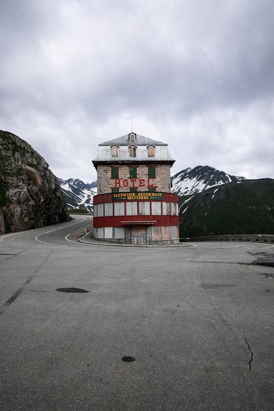 red and white concrete building near mountain under white clouds during daytime in Grotte de Glace, Glacier du Rhône Switzerland