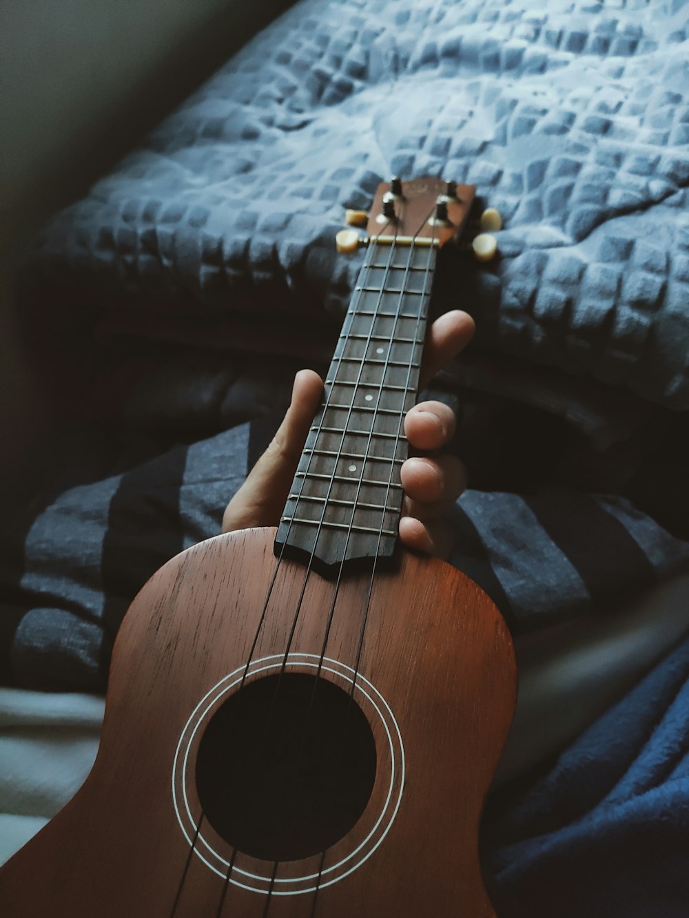 person holding brown acoustic guitar