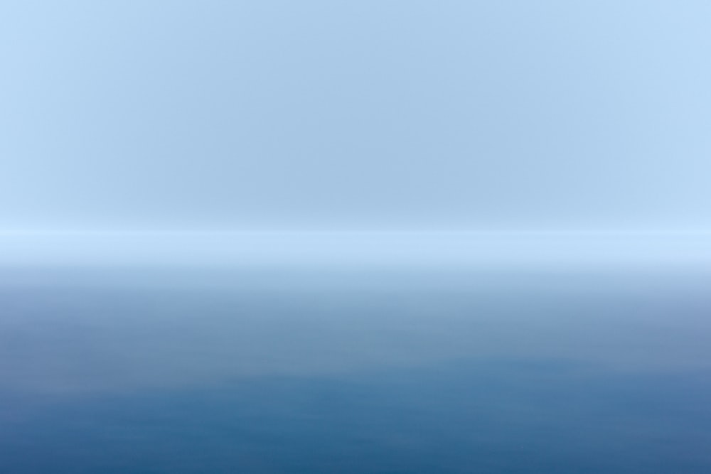 specchio d'acqua blu sotto il cielo bianco durante il giorno