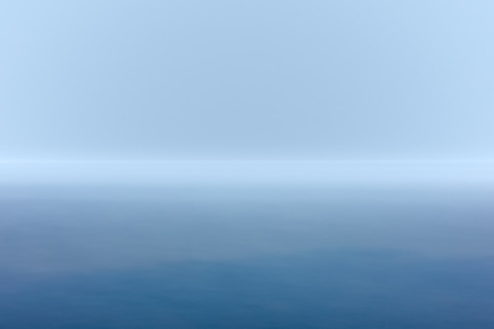 corpo azul de água sob o céu branco durante o dia