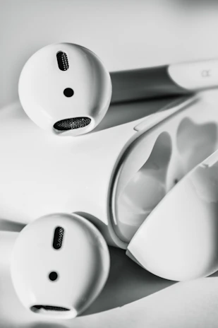 Close-up of sleek wireless earbuds and fast chargers arranged neatly on a minimalist desk.