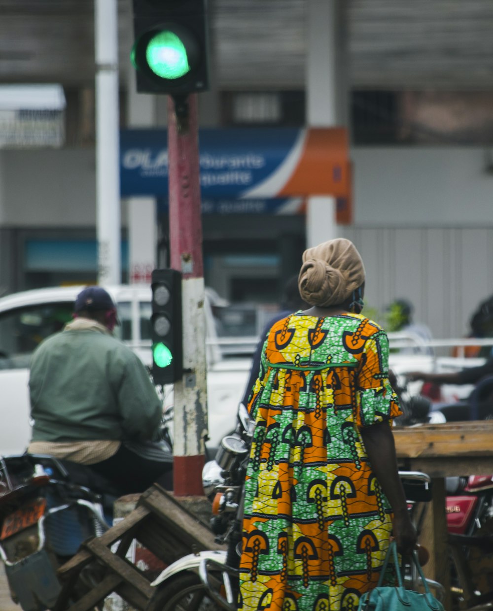 mulher no vestido floral amarelo verde e branco que está na calçada durante o dia