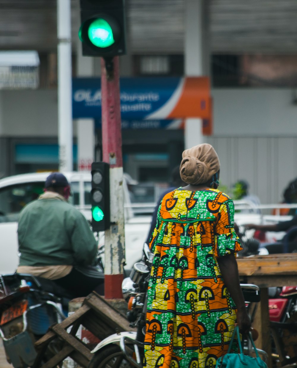 woman in yellow green and white floral dress standing on sidewalk during daytime