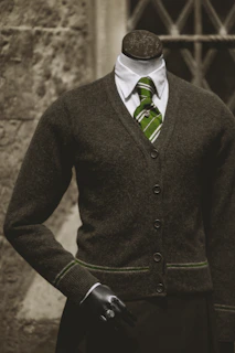 3D mannequin dressed in a dark green men’s shirt and beige trousers with soft gold lighting