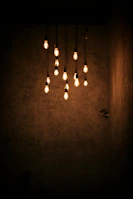 A cluster of chic hanging lights with soft diffused bulbs in a stylish living room.