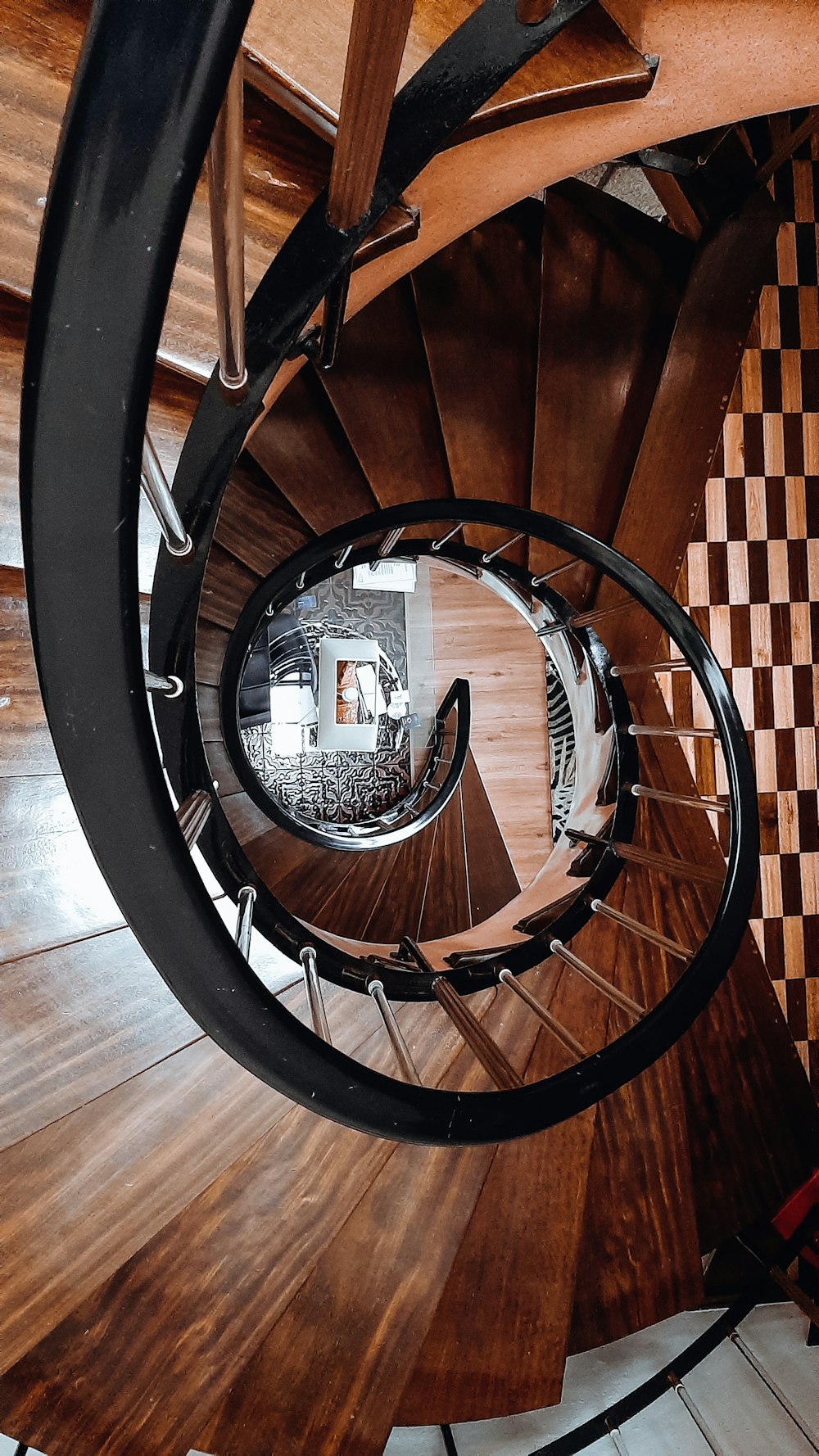 brown wooden spiral staircase with black metal railings