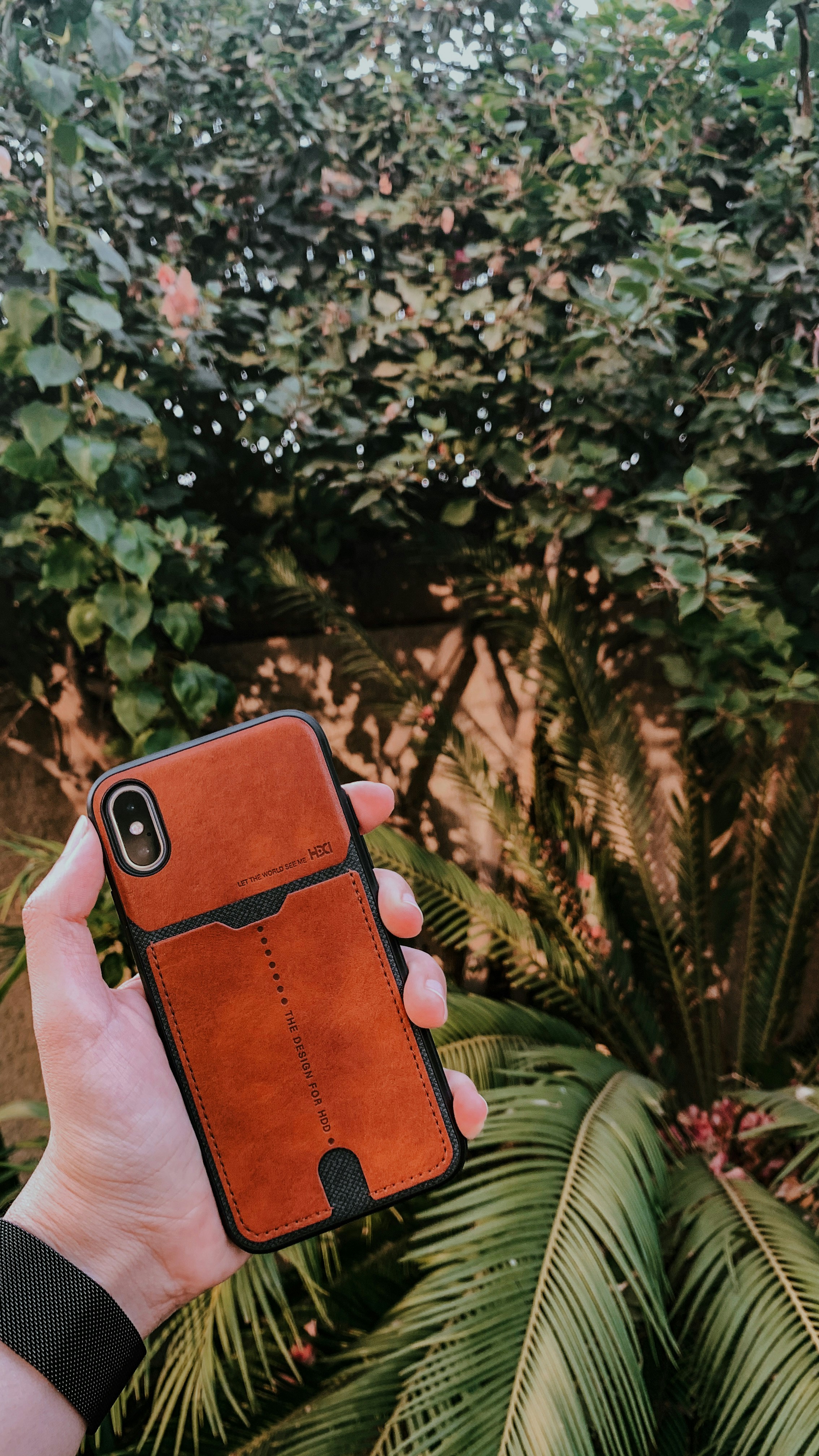 person holding red and black iphone case