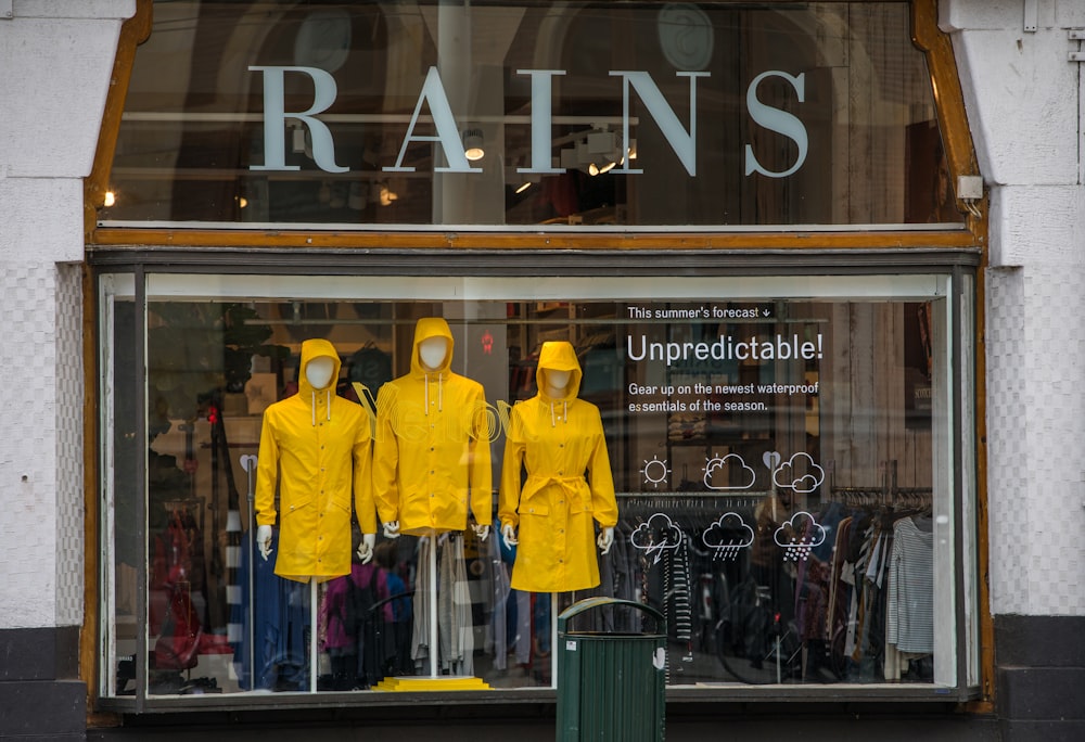 man in yellow coat standing in front of store