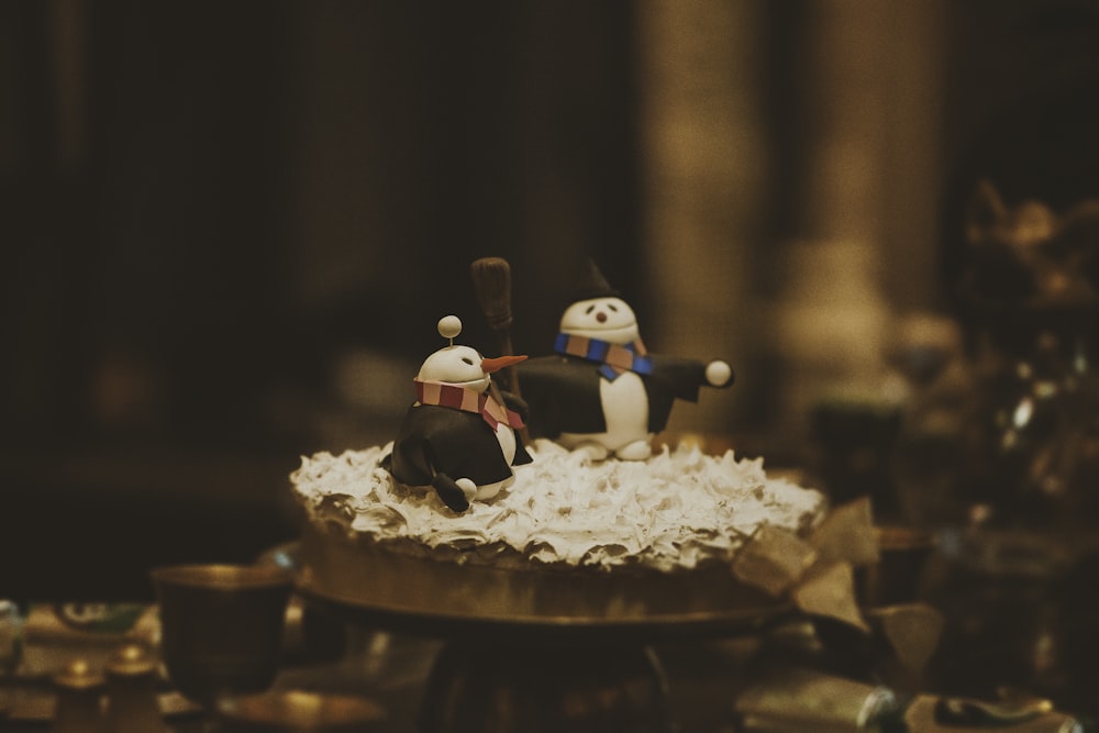 white and black ceramic figurine on brown wooden table