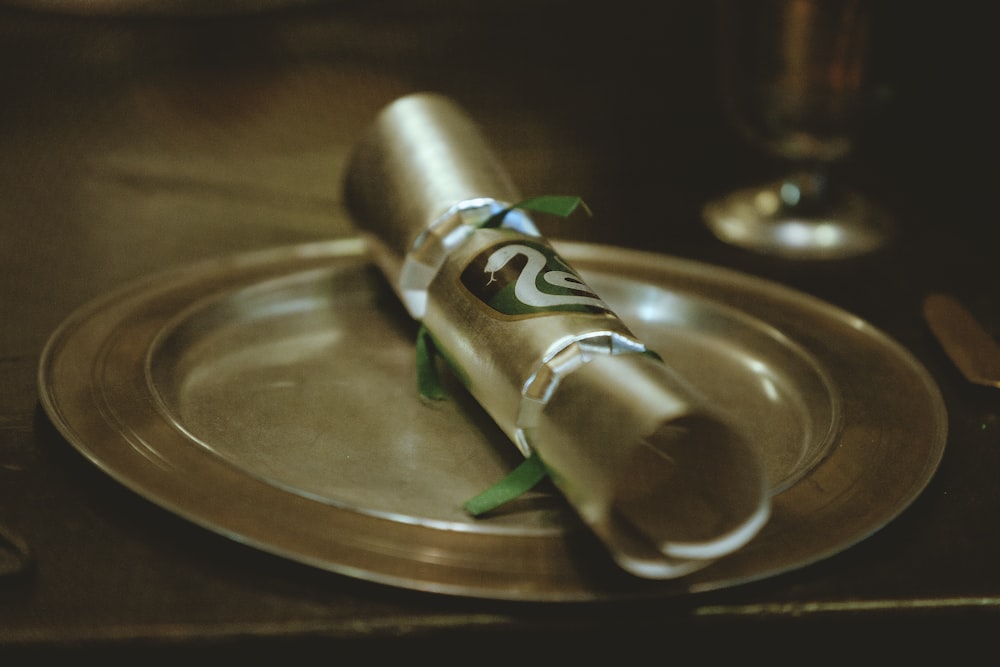 gray and green tube bottle on round stainless steel plate