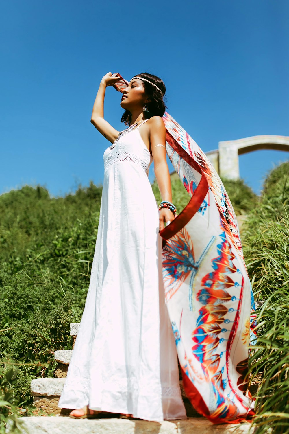 woman in white floral dress standing on green grass field during daytime