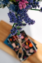 A bright bouquet of colorful flowers resting beside a handwritten note on a rustic wooden table.