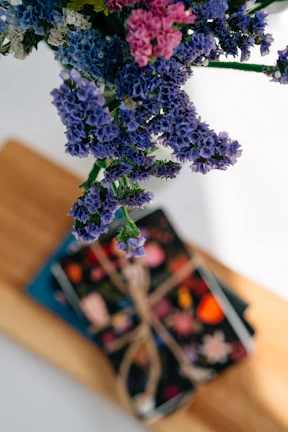 A vibrant display of handmade paper notebooks with floral covers stacked neatly.