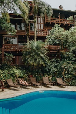 brown wooden house near swimming pool during daytime