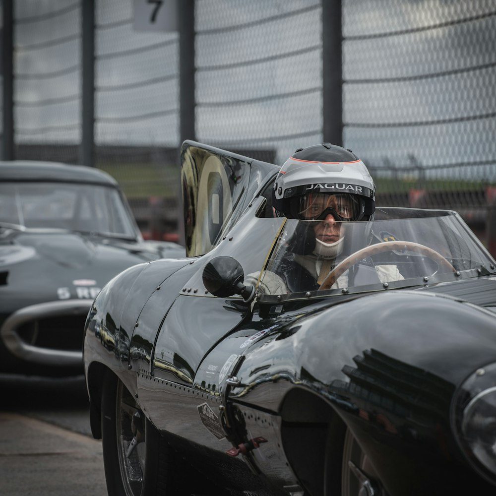 man in black helmet riding black convertible car