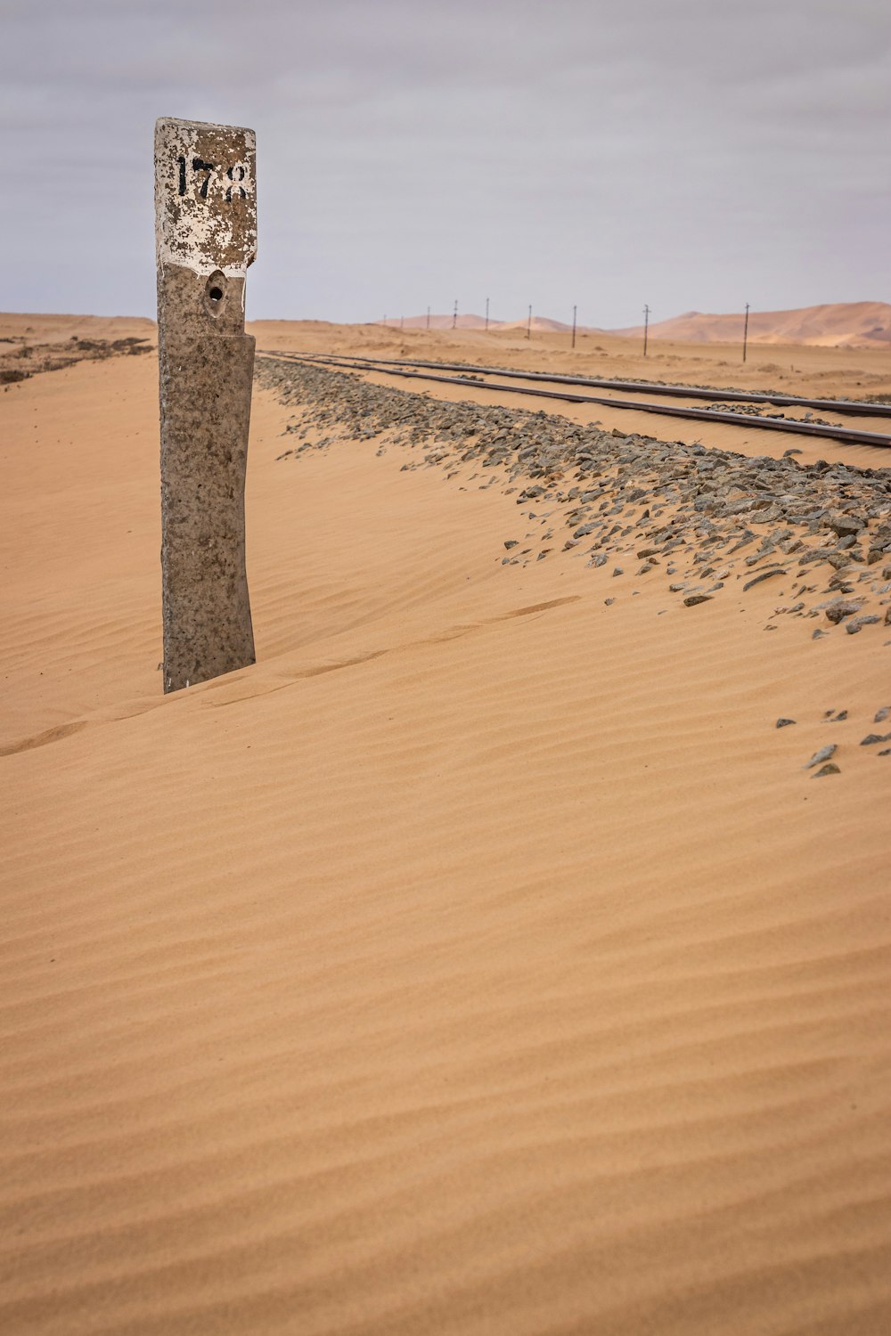 brown wooden post on brown sand during daytime