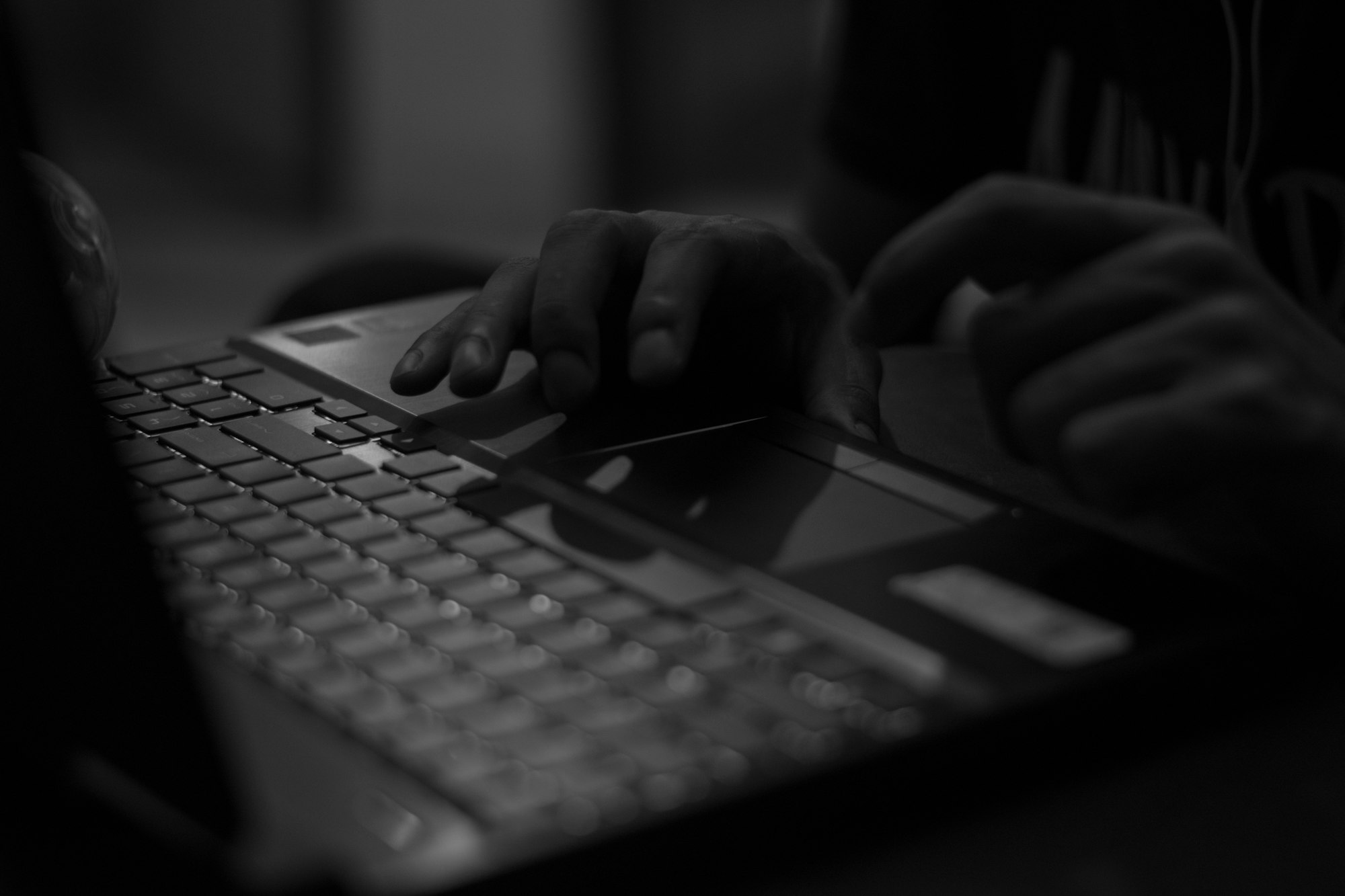 grayscale photo of person using laptop computer